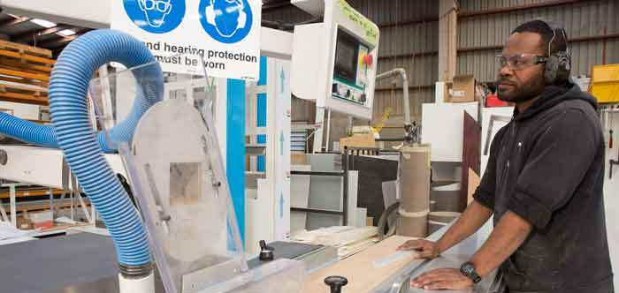 [image] Man operating machine at manufacturing site