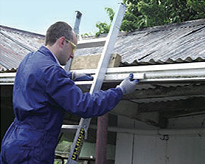 [image] A worker maintains three points of contact while at the top of a ladder