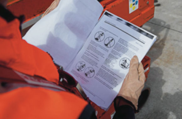 [image] Worker's hands holding an open training guide