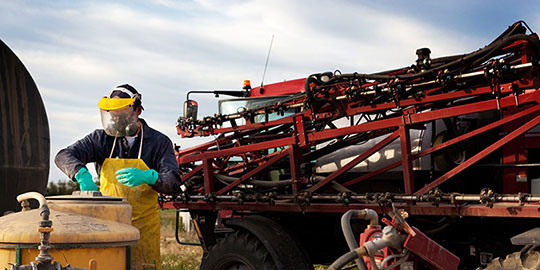 [image] Worker refilling high clearance sprayer